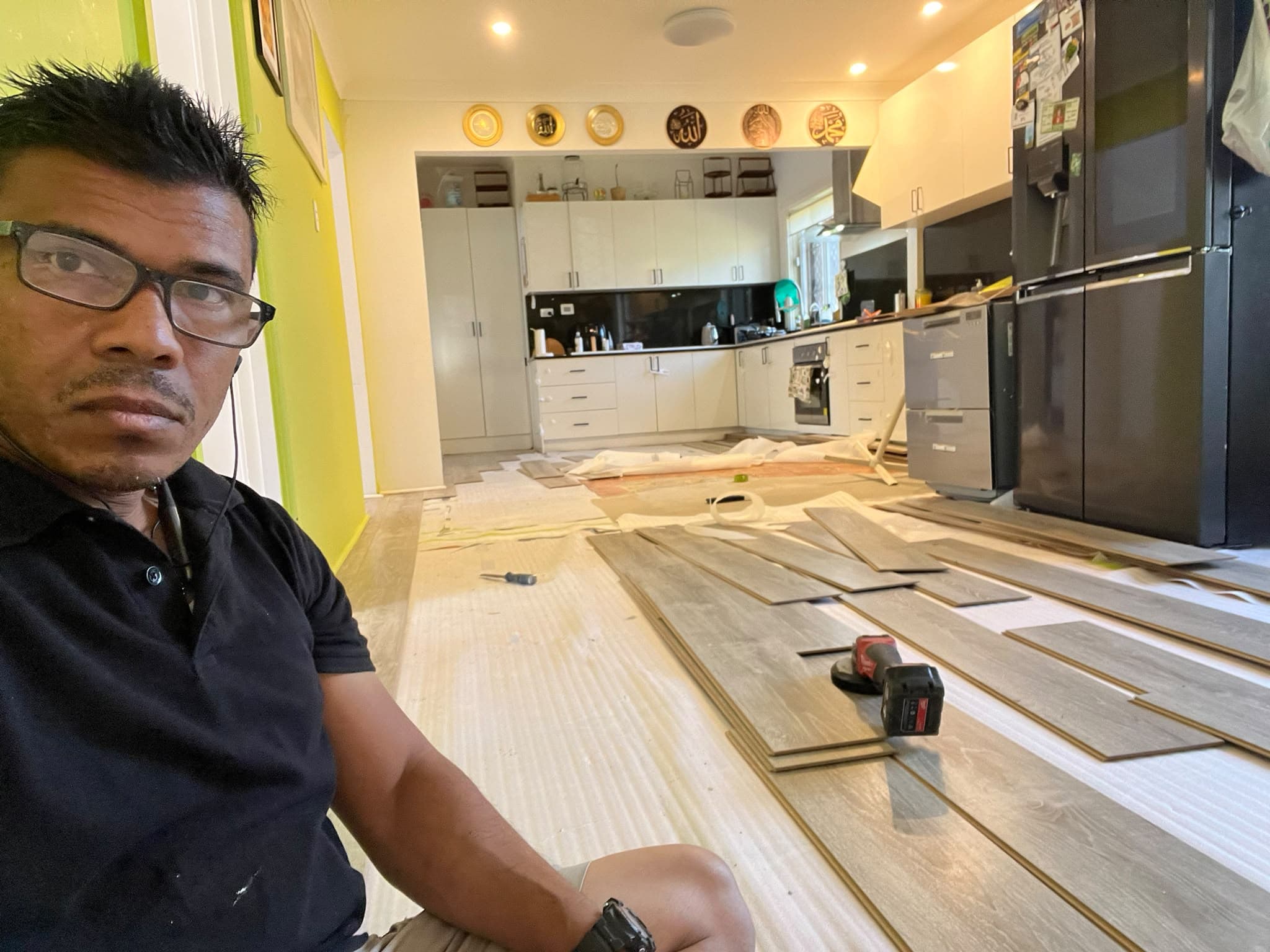 Zaman Lenin of Budget Handyman AU laying laminate flooring in a Sydney kitchen