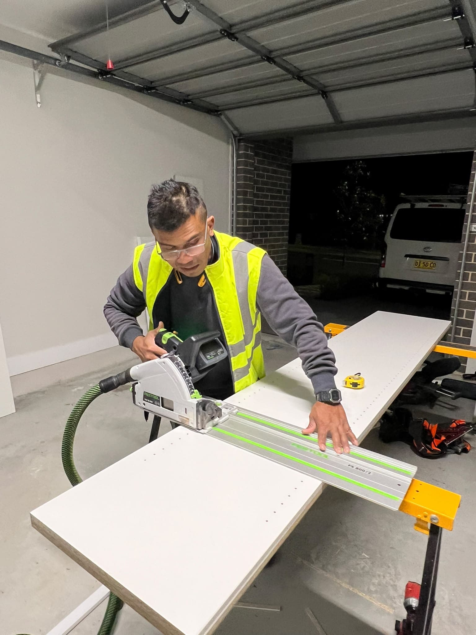 Zaman Lenin, owner of Budget Handyman, cutting a panel with a track saw